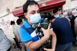 印度酒类门店恢复营业后被挤爆，警察举起棍子维持秩序