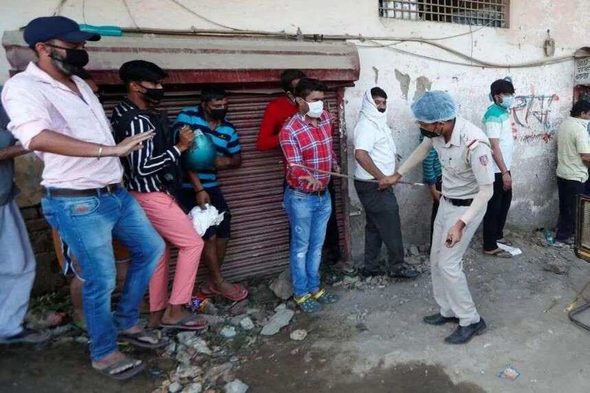印度酒类门店恢复营业后被挤爆，警察举起棍子维持秩序